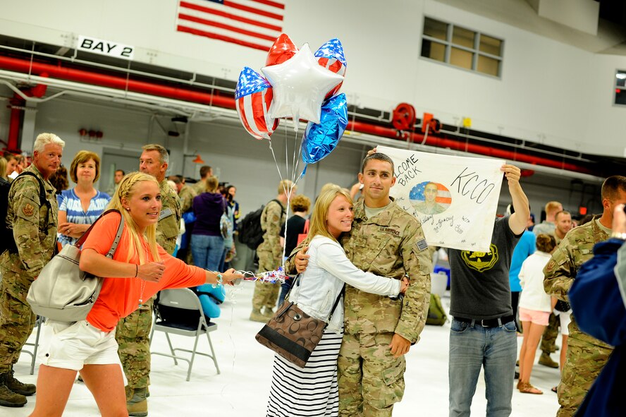 Staff Sgt. Jarrod Konz hugs a loved one for the first time on over two months. Konz, a fuels systems journeyman, along with about 200 other 180th Fighter Wing members returned from an Air Expeditionary Force deployment lasting for just over two months. The 180th FW initially deployed to Djibouti, Africa in support of the Combined Joint Task Force-Horn of Africa (CJTF-HOA) to conduct stability operations in the area. At the end of June, members of the AEF were forward deployed to Muwaffaq Sulti AF, Azraq, Jordan, as part of Exercise Eager Lion. Eager Lion is a recurring, multinational exercise designed to strengthen military to military relationships and enhances regional security and stability by responding to modern day scenarios. Air National Guard Photo by Mast er Sgt. Beth Holliker (Released).