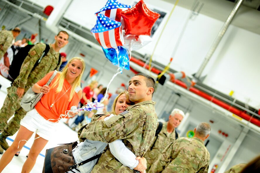 Staff Sgt. Jarrod Konz hugs a loved one for the first time in over two months. Konz, a fuels systems journeyman, along with about 200 other 180th Fighter Wing members returned from an Air Expeditionary Force deployment lasting for just over two months. The 180th FW initially deployed to Djibouti, Africa in support of the Combined Joint Task Force-Horn of Africa (CJTF-HOA) to conduct stability operations in the area. At the end of June, members of the AEF were forward deployed to Muwaffaq Sulti AF, Azraq, Jordan, as part of Exercise Eager Lion. Eager Lion is a recurring, multinational exercise designed to strengthen military to military relationships and enhances regional security and stability by responding to modern day scenarios. Air National Guard Photo by Mas er Sgt. Beth Holliker (Released).