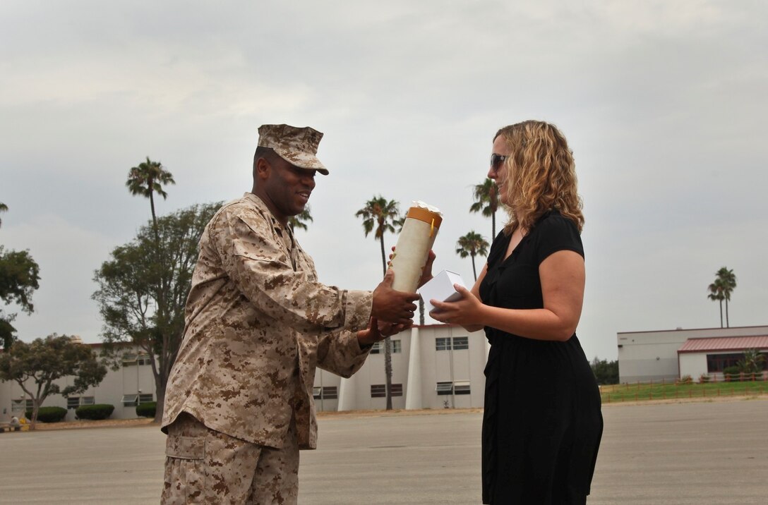 MARINE CORPS BASE CAMP PENDLETON, Calif. (July 11, 2013) Rebecca Roman, family readiness officer, Command Element, 15th Marine Expeditionary Unit, receives a farewell gift from Sgt. Maj. John W. Scott, sergeant major, 15th Marine Expeditionary Unit, during a unit formation held on the Camp Del Mar Parade Deck aboard Camp Pendleton, Calif., July 11. Roman was integral in keeping Marine’s families updated during the unit’s Western Pacific 12-2 deployment. (U.S. Marine Corps photo by Cpl. Emmanuel Ramos/Released)
