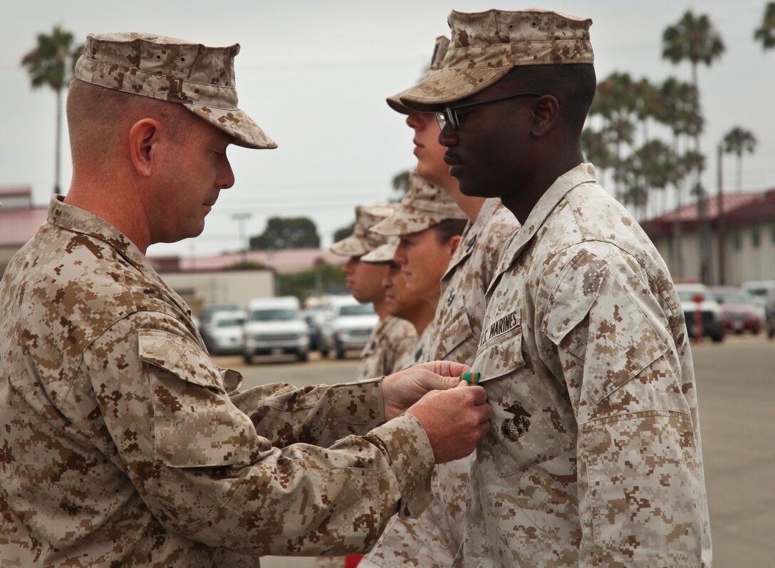MARINE CORPS BASE CAMP PENDLETON, Calif. (July 11, 2013) Corporal Robert A. McKenzie, supply administrative clerk, Command Element, 15th Marine Expeditionary Unit, receives a Navy and Marine Corps Achievement Medal from Lt. Col. John R. O’Neal, commanding officer, Command Element, 15th Marine Expeditionary Unit, during an awards ceremony held on the Camp Del Mar Parade Deck aboard Camp Pendleton, Calif., July 11. McKenzie received the award for the superior performance of his duties as the unit’s supply administrative clerk. McKenzie, 22, is from Atlanta. (U.S. Marine Corps photo by Cpl. Emmanuel Ramos/Released)