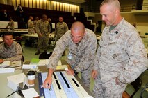 Capt. Wilson Moore, a member of the Amphibious Combat Vehicle team, explains the tradable capabilities matrix to Gunnery Sgt. Chris Breen, an infantryman from Twentynine Palms, Calif., during the ACV Warfighter Requirements Workshop July 9 at Marine Corps Base Quantico, Va. The ACV team held the workshop to gain input from fleet Marines about the capabilities they deem important for a high water speed vehicle. 