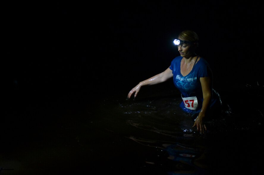 An obstacle race participant wades through water on Barksdale Air Force Base, La., July 12, 2013. Participants ran, jumped, climbed, crawled, and swam to get to the finish line. After the race participants were able to enjoy free refreshments and exchange stories around a bon-fire. (U.S. Air Force photo/Senior Airman Micaiah Anthony)
