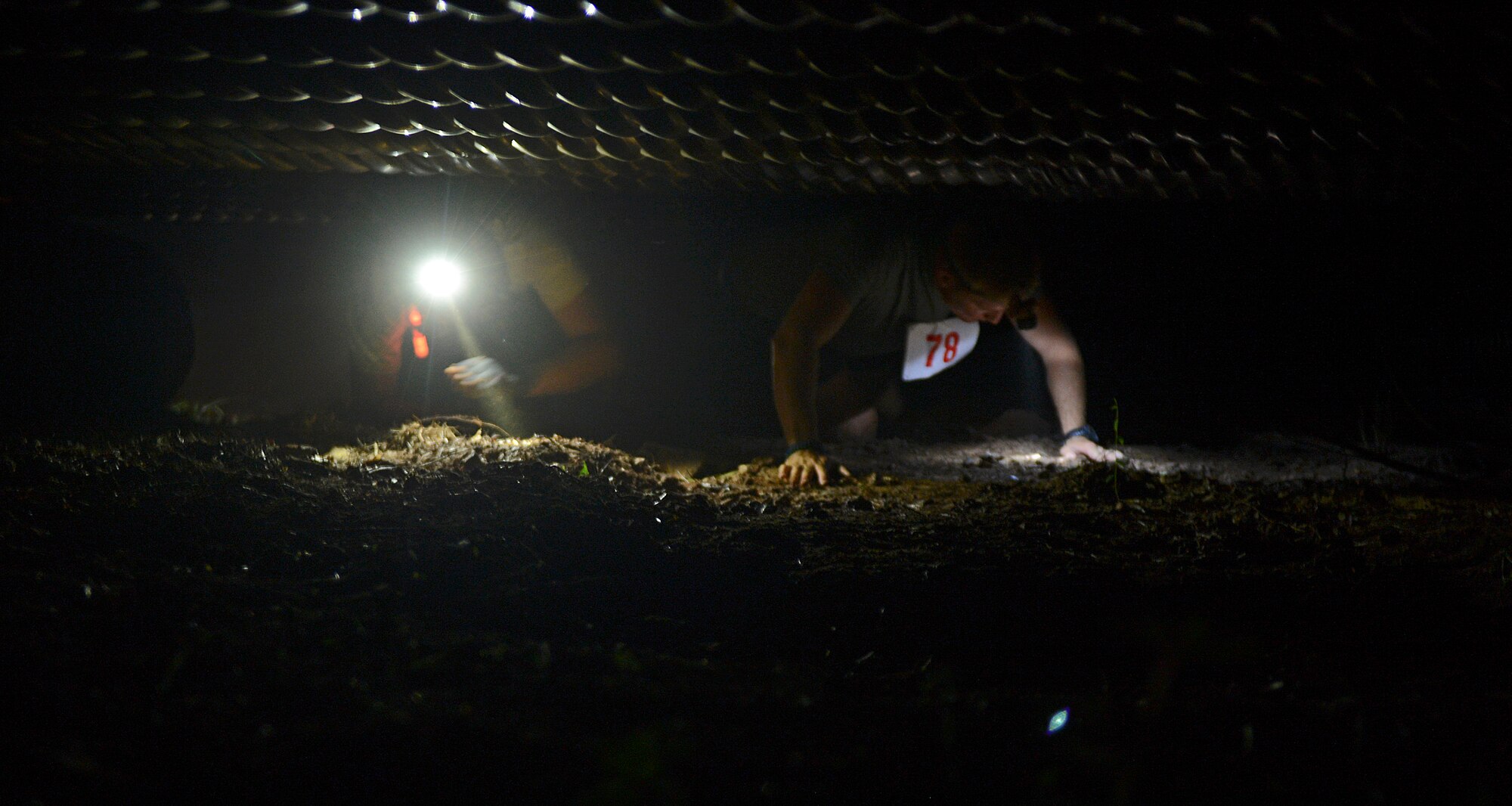 Participants crawl under a series of pipes on Barksdale Air Force Base, La., July 12, 2013. Participants had the choice to crawl under, go through or climb over the obstacle. (U.S. Air Force photo/Senior Airman Micaiah Anthony) 