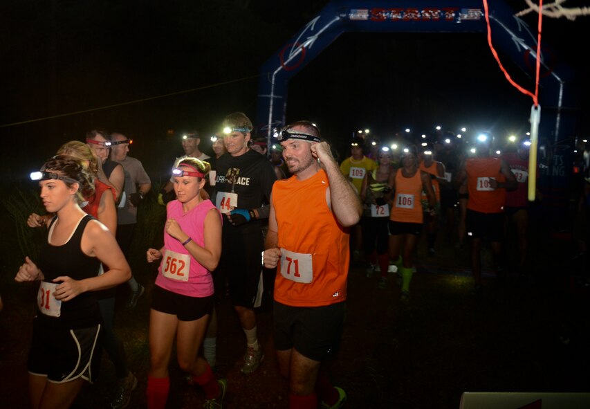 Participants cross the starting line on Barksdale Air Force Base, La., July 12, 2013. Approximately 600 Airmen, retires, dependents and civilians signed up for the race. Running bibs with internal sensors were used to track participants' course times. (U.S. Air Force photo/Senior Airman Micaiah Anthony)
