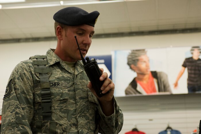 Tech. Sgt. Christopher Spicher, 99th Security Forces Squadron patrolman, communicates information to his team by radio during an active-shooter exercise at the Exchange July 9, 2013, at Nellis Air Force Base, Nev. SFS Airmen entered the building to apprehend a suspect, assess the wounded and report back casualty and suspect information to the emergency responders. (U.S. Air Force photo by Airman 1st Class Christopher Tam)