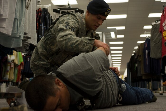 Staff Sgt. Jordan Young, 99th Security Forces Squadron law enforcement desk controller, searches for possible weapons on a suspect during an active-shooter exercise at the Exchange July 9, 2013, at Nellis Air Force Base, Nev. SFS Airmen are evaluated by their peers on their ability to respond and recover from a mass casualty event. (U.S. Air Force photo by Airman 1st Class Christopher Tam)