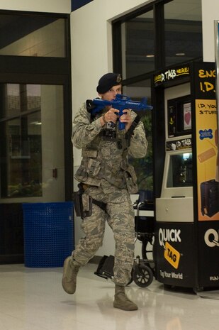 Airman 1st Class Alex Billado, 99th Security Forces Squadron law enforcement desk controller, searches for an active shooter during an active-shooter exercise at the Exchange July 9, 2013, at Nellis Air Force Base, Nev. Using the Exchange for the active-shooter exercise gave SFS Airmen and exchange employees’ proper training should an active-shooter incident happen on base. These types of exercises are held twice a year in various locations around base to maintain mission readiness. (U.S. Air Force photo by Airman 1st Class Christopher Tam)