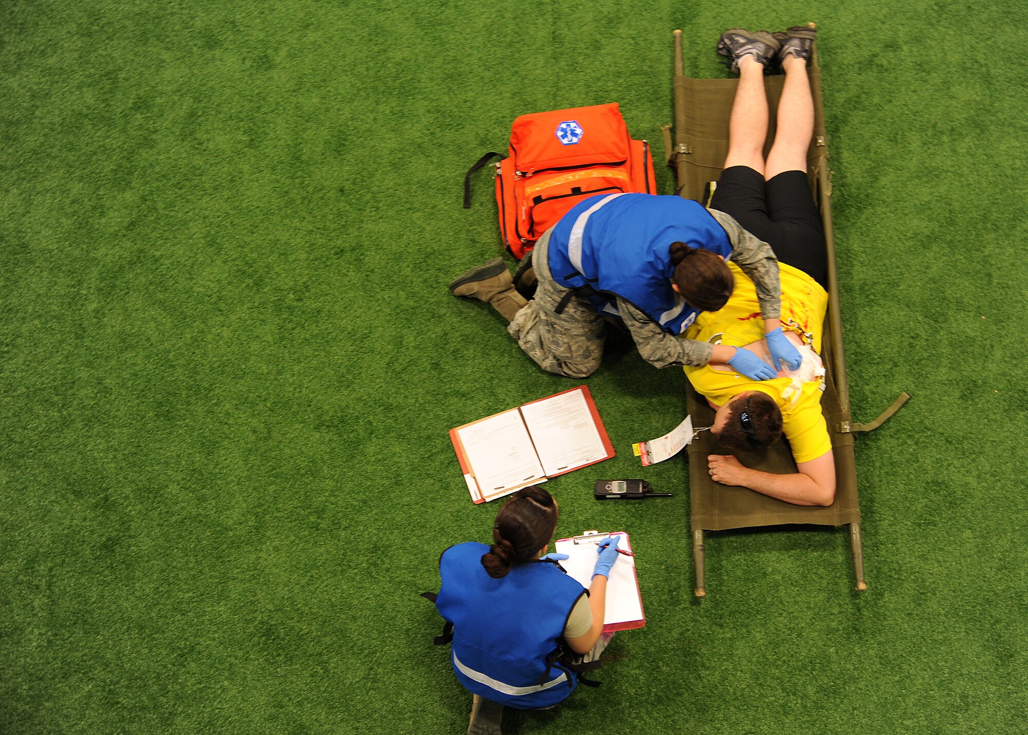 Members of the 319th Medical Group simulate providing medical support to a tornado exercise “victim” on June 21, 2013, on Grand Forks Air Force Base, N.D. The 319th Air Base Wing, and first-responders from Grand Forks city, conducted the exercise to hone their skills in advance of the upcoming storm and tornado season.  Part of the exercise required base medical personnel to simulate evacuating to an alternate site to provide medical and mental care to mass casualties.  (U.S. Air Force Photo/ Airman 1st Class Xavier Navarro)