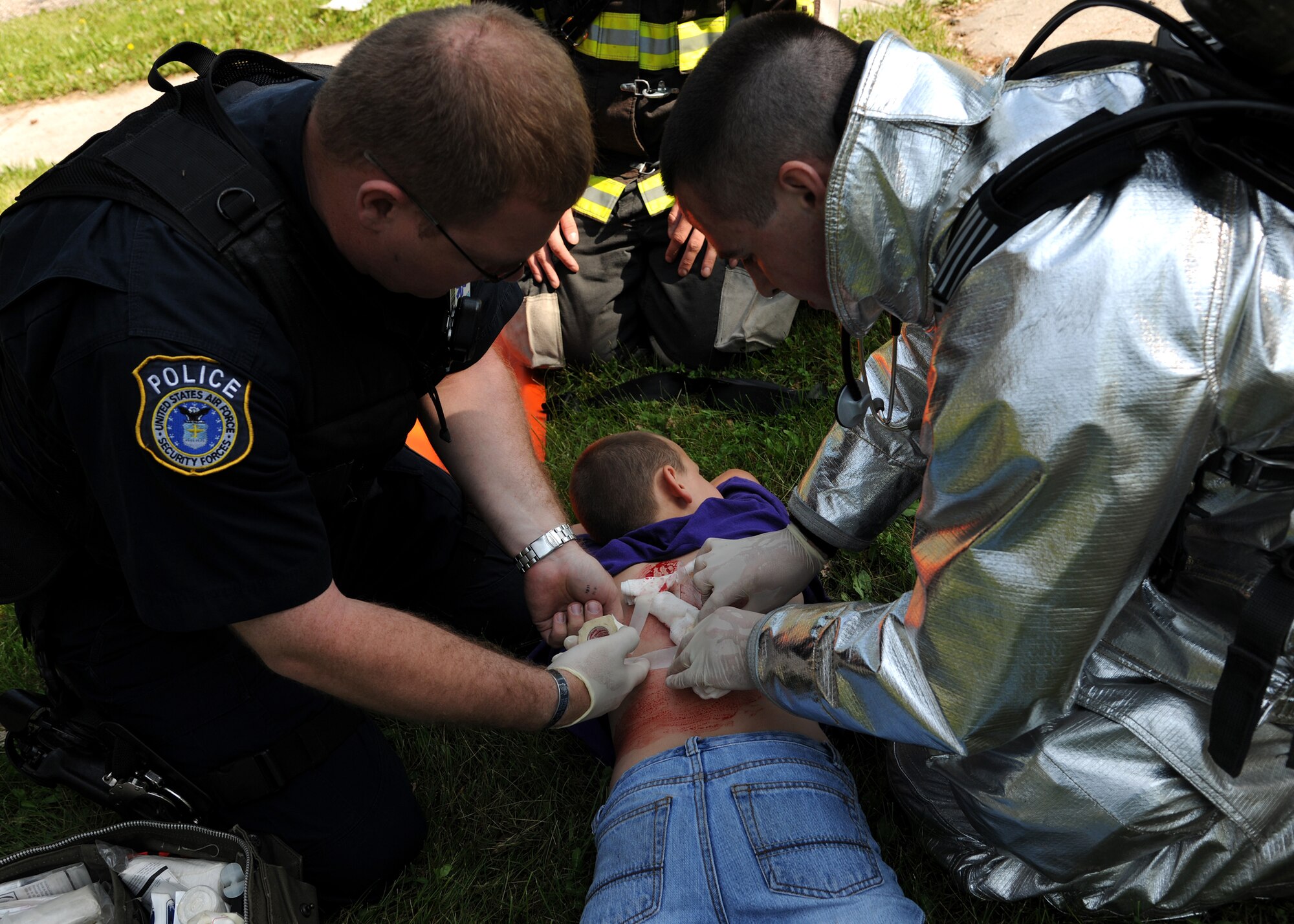 An officer and a firefighter prepare a “victim” during a tornado exercise on June 21, 2013, on Grand Forks Air Force Base, N.D. Members of the 319th Air Base Wing and Grand Forks city first-responders practiced their response capabilities in case of a real tornado. (U.S. Air Force photo/Airman 1st Class Ashley Nicole Taylor)