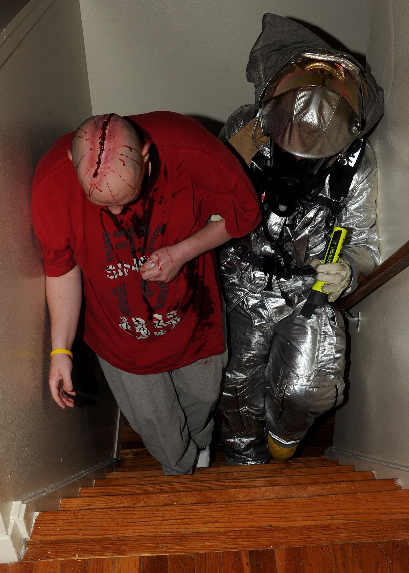A firefighter from the 319th Civil Engineer Squadron escorts an “injured civilian” to safety during a tornado exercise on June 21, 2013, on Grand Forks Air Force Base, N.D. Firefighters practiced real-world scenarios to hone their response capabilities in case of a real tornado. (U.S. Air Force photo/Airman 1st Class Ashley Nicole Taylor)