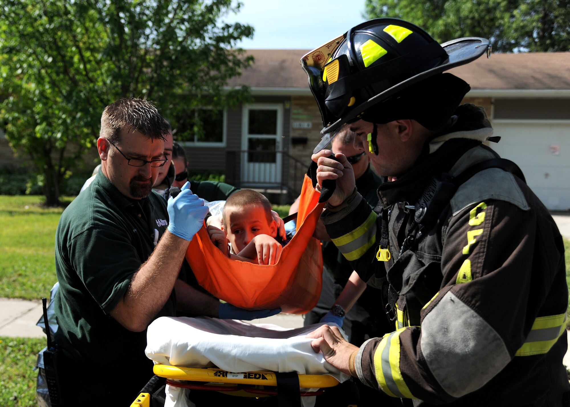 Firefighters from the 319th Civil Engineer Squadron work with Altru Health System medics to escort a “victim” during a tornado exercise on June 21, 2013, on Grand Forks Air Force Base, N.D. The 319th Air Base Wing teamed up with off-base first-responders from the city of Grand Forks to hone their joint response capabilities if a real tornado struck the base. (U.S. Air Force photo/Airman 1st Class Ashley Nicole Taylor)
