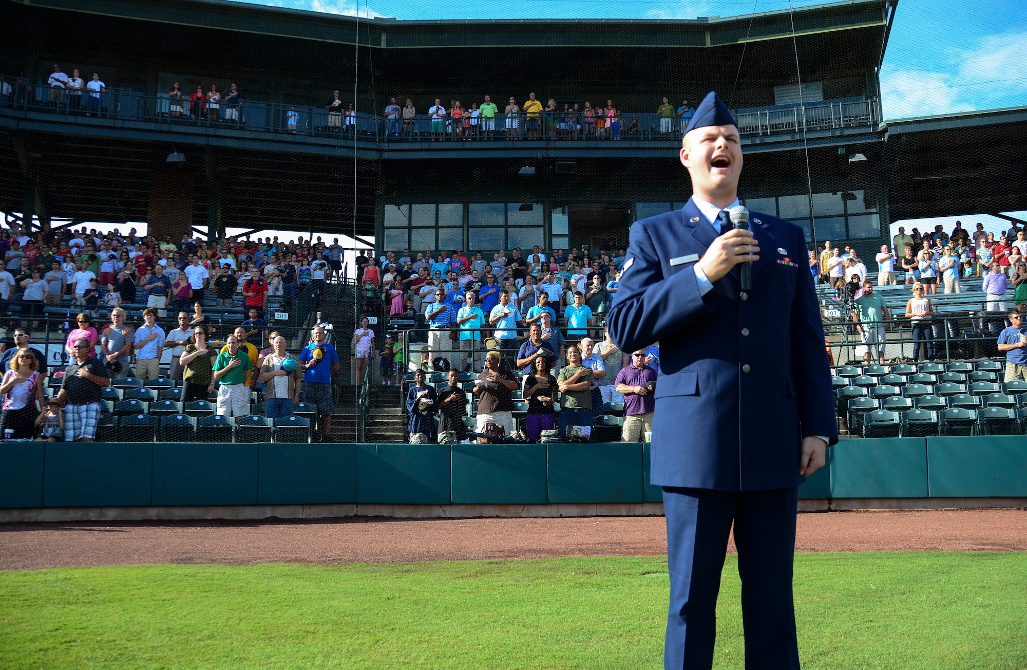 Airman 1st Class Michael Reeves, 628th Air Base Wing Public Affairs broadcaster, sings the National Anthem during Military Appreciation Night July 13, 2013, at the Joseph P. Riley Jr. ballpark in Charleston, S.C. Reeves performed for more than 5,000 attendees. (U.S. Air Force photo/ Staff Sgt. Anthony Hyatt)