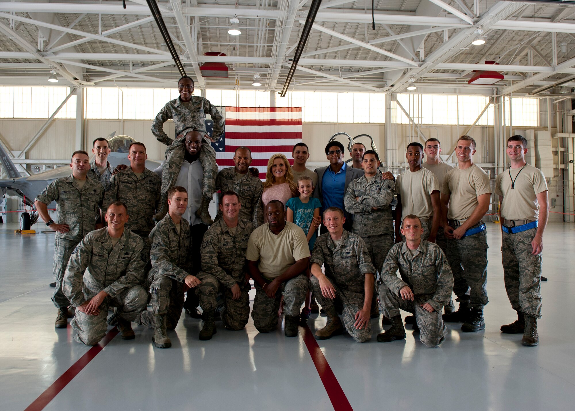 Members of the 1st Fighter Wing take a group photo with WWE Superstars Darren Young and Titus O’Neil, and WWE Diva Natalya at the 94th Fighter Squadron at Langley Air Force Base, July 9, 2013. The WWE entertainers signed autographs and took photos with Joint Base Langley-Eustis Soldiers, Airmen and their families. (U.S. Air Force photo by Staff Sgt. John D. Strong II/Released)