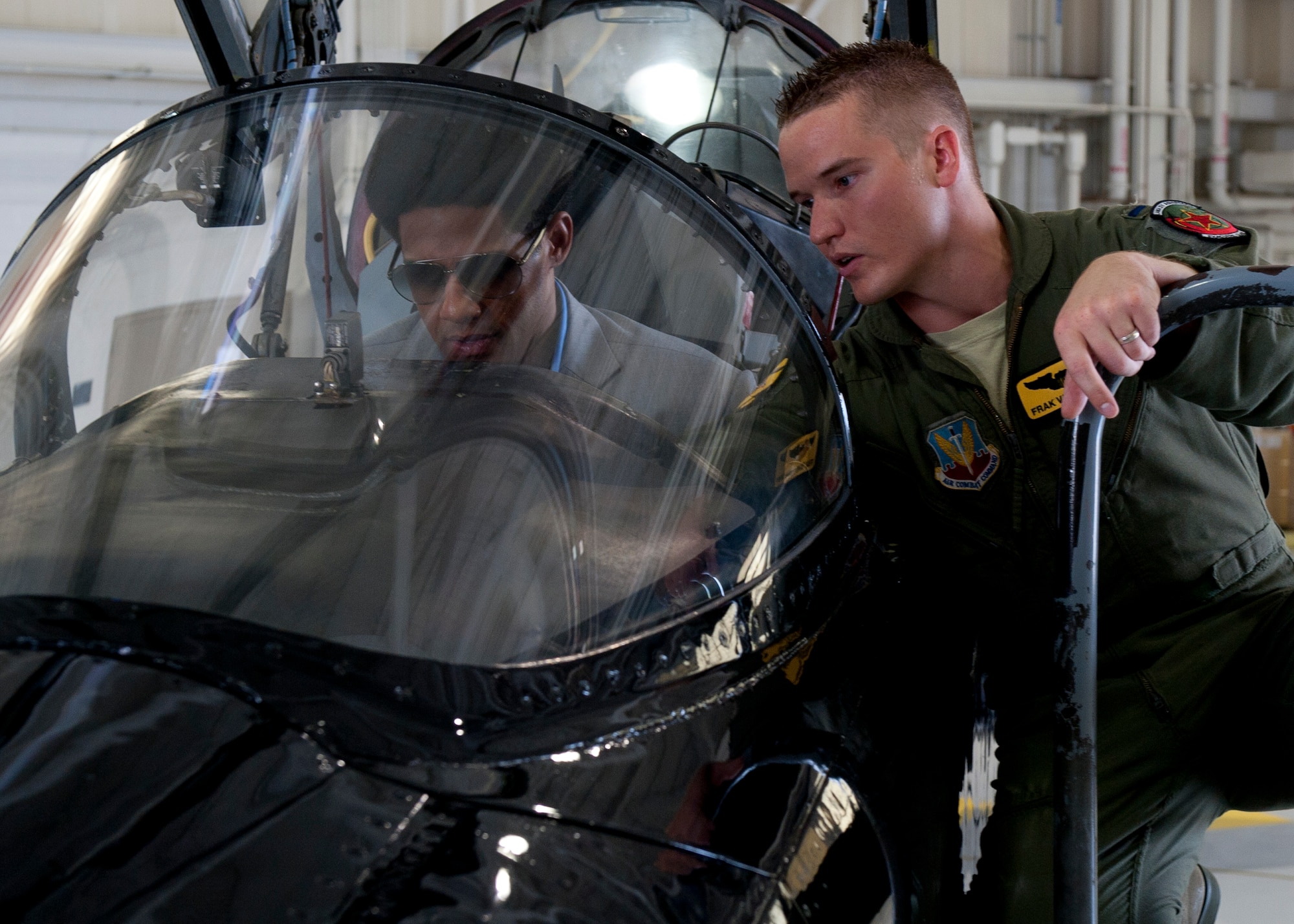 U.S. Air Force 1st Lt. Frank Vandegriff, 27th Fighter Squadron pilot, explains the capabilities and instruments of the T-38A talon to WWE Superstar Darren Young at the 94th Fighter Squadron at Langley Air Force Base, July 9, 2013. Young, along with WWE Superstar Titus O’Neil and WWE Diva Natalya, interacted with the T-38A Talon and received a tour of the F-22A Raptor. (U.S. Air Force photo by Staff Sgt. John D. Strong II/Released)