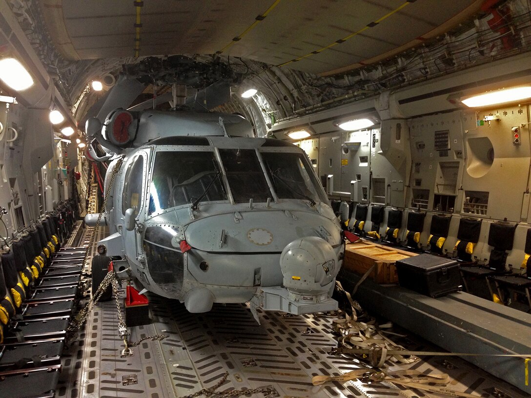 A Navy H-60 Seahawk is loaded onto a McChord C-17 July 5 at McChord Field, Wash. The helicopter is being airlifted to Australia to be used as part of a U.S. and Australian training exercise called Talisman Saber 2013. (U.S. Air Force photo by Lt. Col. Jon Bowser)