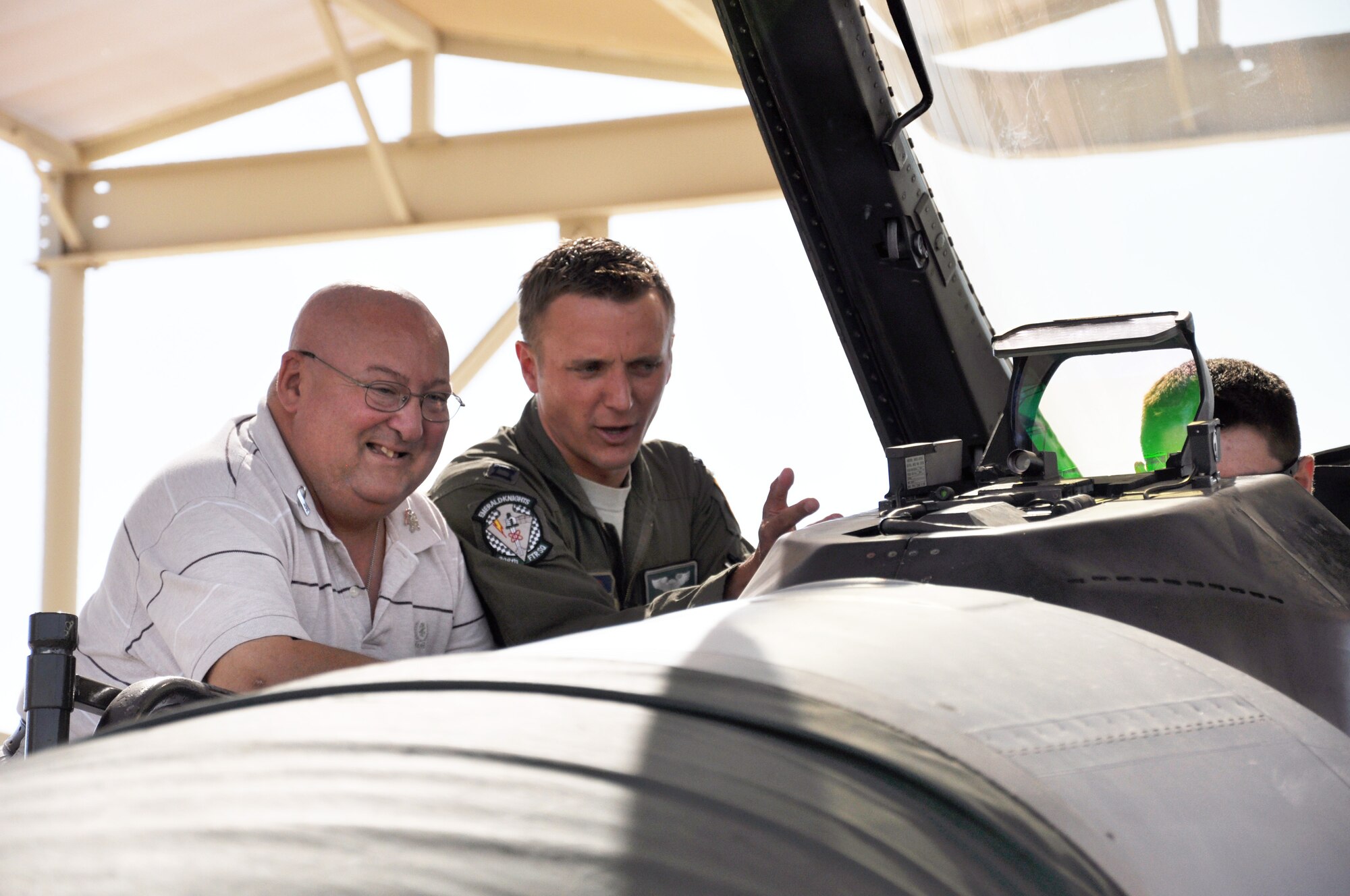 Glenn Schallman listens as 1st Lt. Patrick Nolan, 308th Fighter Squadron pilot, goes over the controls of an F-16 on the flightline June 20 at Luke Air Force Base. Schallman suffers from a rare form of brain tumor that was deemed inoperable in 2002. (U.S. Air Force photo/Staff Sgt. Luther Mitchell Jr.)