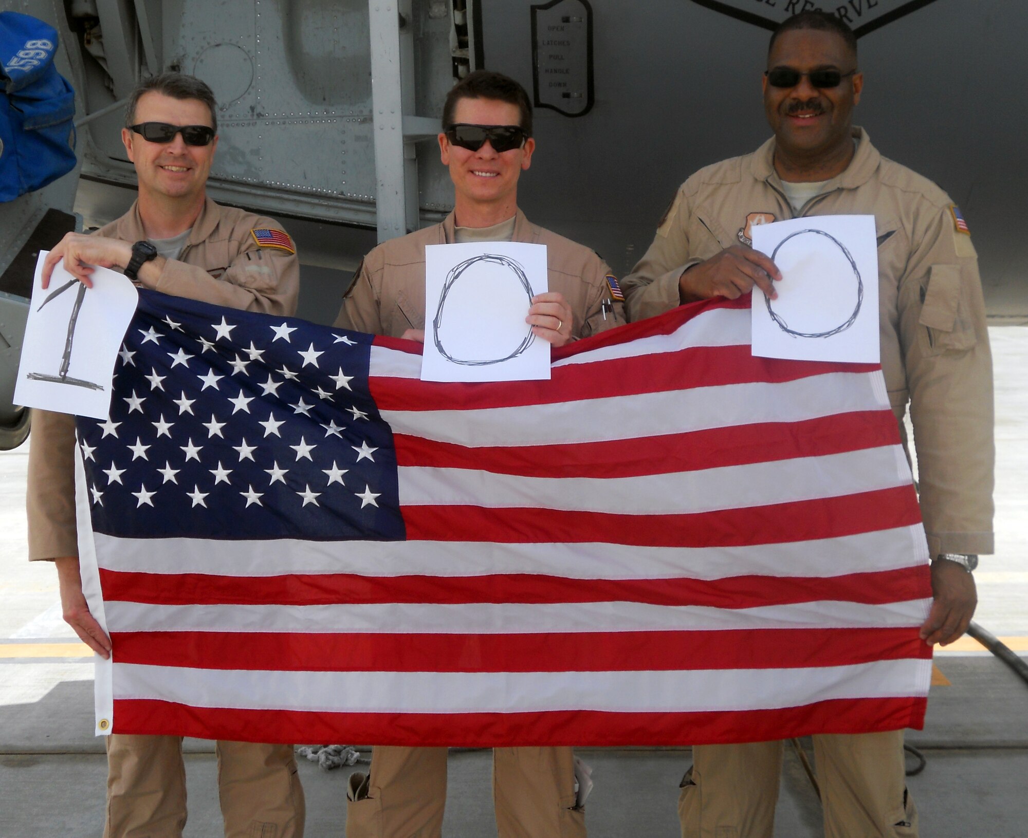Senior Master Sgt. John Wallman, Lt. Col. Daniel Malles, and Lt. Col. Esteban Ramirez pose with the flag flown during Ramirez's 100th combat mission.  Ramirez, a traditional Reservist assigned to the 931st Air Refueling Group, presented the flag to his civilian employer, Beechcraft Corporation, during a ceremony today to thank them for their support during his deployments.  (U.S. Air Force photo courtesy Lt. Col. Esteban Ramirez)