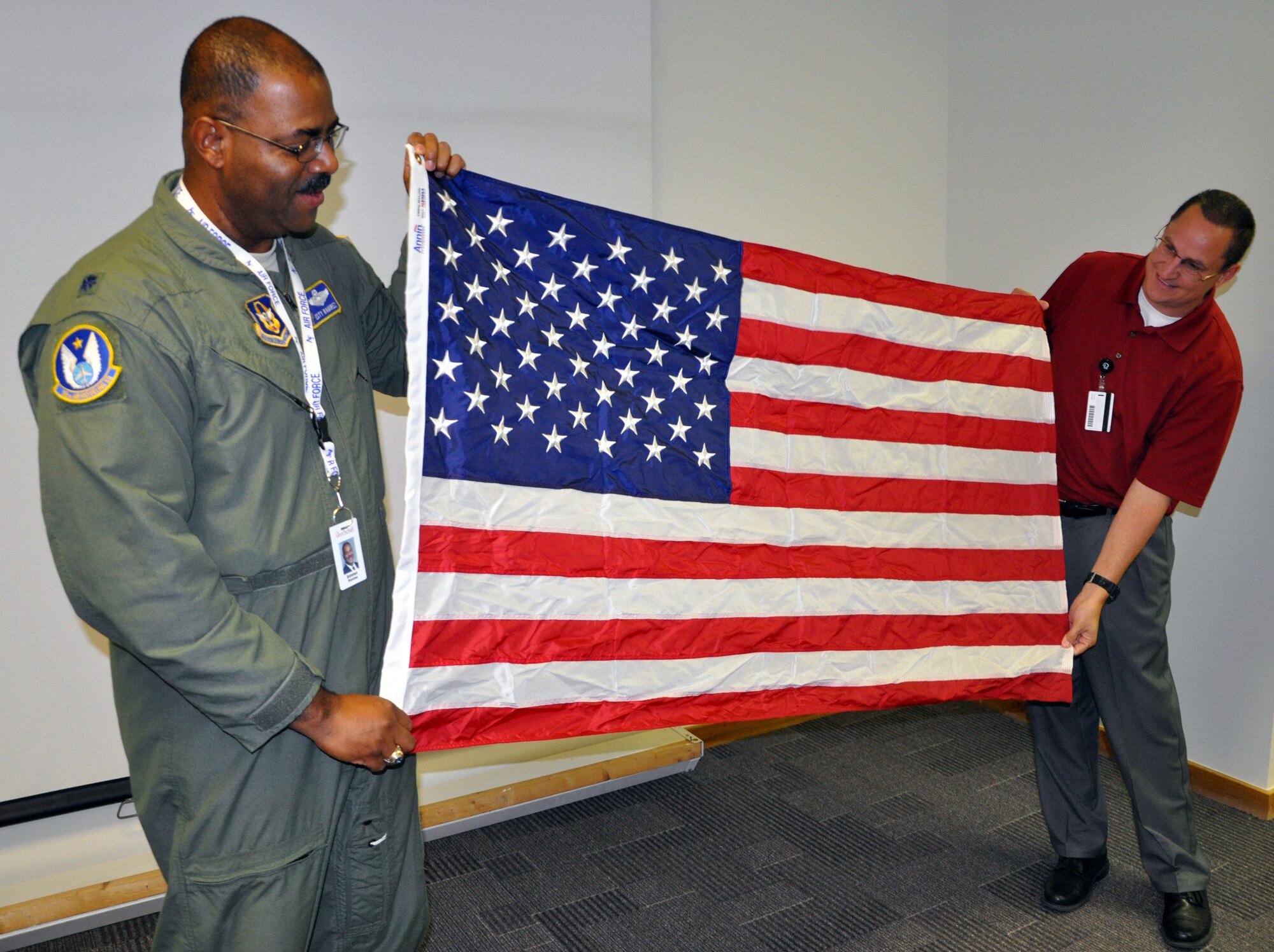 Lt. Col. Esteban Ramirez, a pilot assigned to the 18th Air Refueling Squadron, presents the flag flown on his 100th combat mission to his employer, Beechcraft Corporation, July 15, 2013.  Ramirez is a traditional Reservists and was thanking his employer for their outstanding support during his recent deployments.  (U.S. Air Force photo by Capt. Zach Anderson)