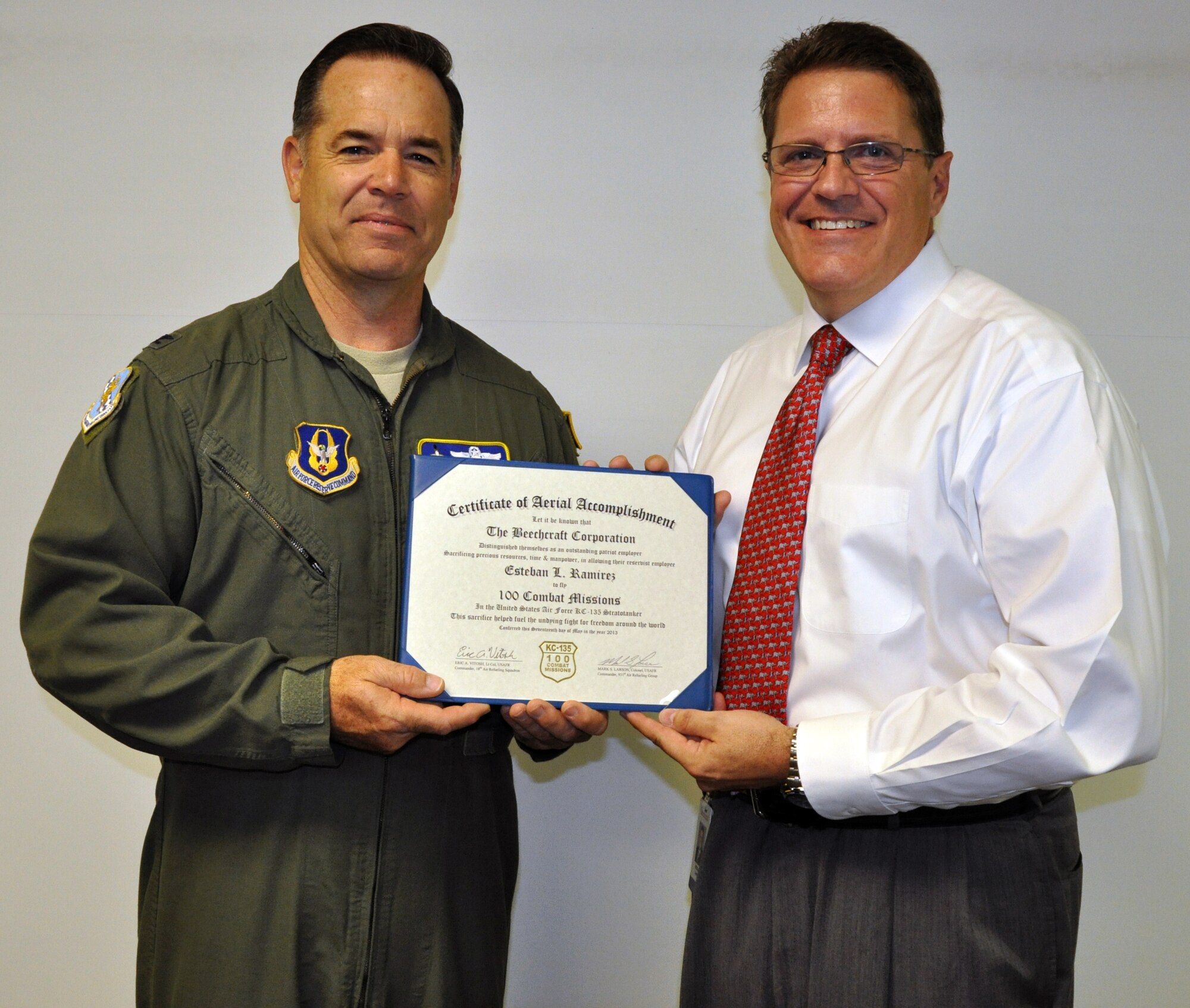 Col. Mark S. Larson, commander of the Air Force Reserve 931st Air Refueling Group, presents a certificate of appreciation to Bill James of Beechcraft Corporation, July 15, 2013.  Larson, along with several other members of the 931st, presented a "100 combat mission" patch and a certificate of appreciation to the local employer to thank them for their outstanding support of Lt. Col. Esteban Ramirez, a traditional Reservists employed at Beechcraft, during his recent deployments.  (U.S. Air Force photo by Capt. Zach Anderson)