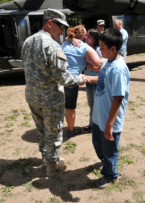 Montana National Guard Adjutant General, Maj. Gen. Matthew Quinn, shakes hands with a young camper attending Camp Runnamucka, held at Camp Rotary located near Monarch, Mont. on June 27, 2013. (Air Force photo/Senior Master Sgt. Eric Peterson)

