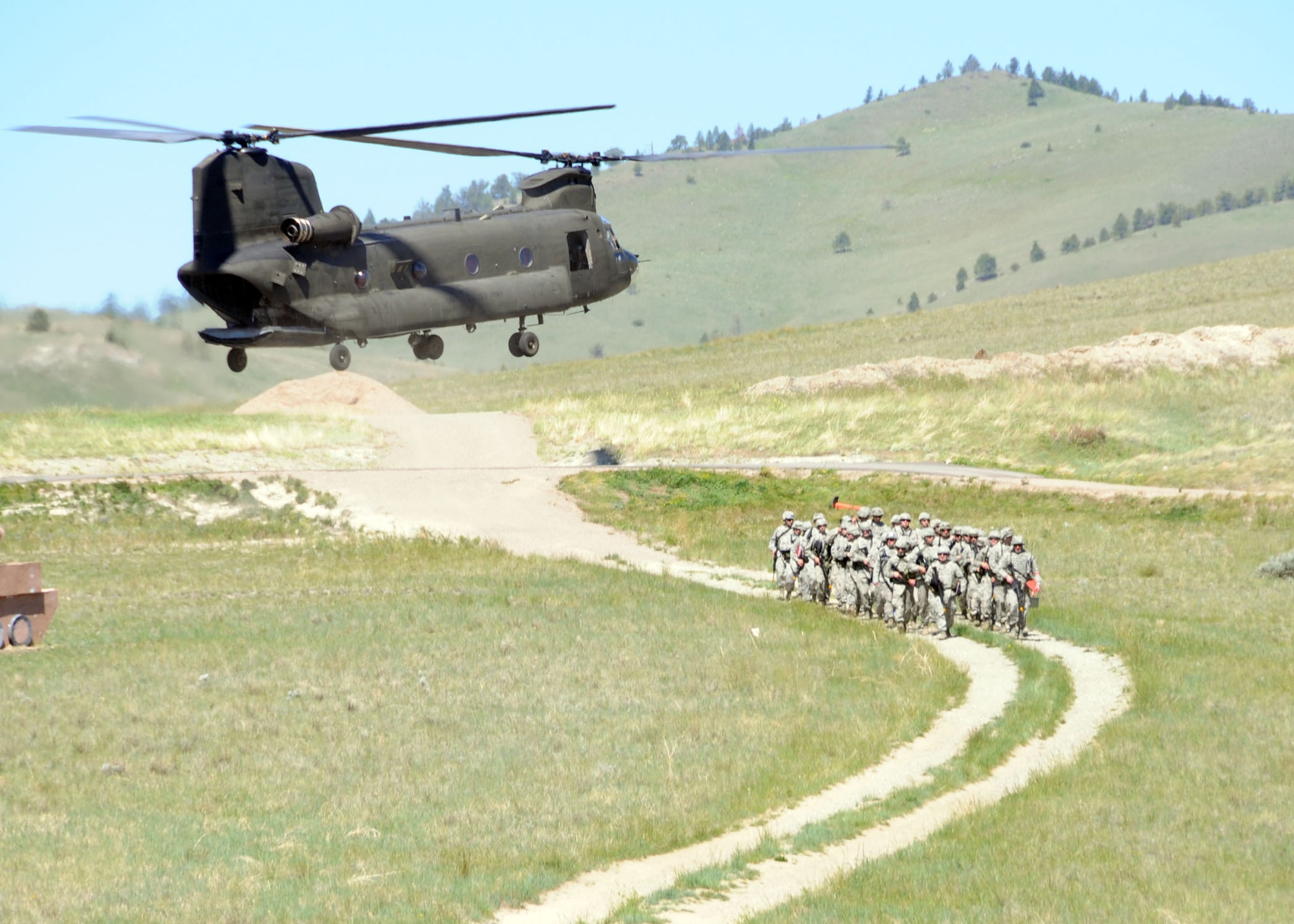 Members of the 219th RED HORSE Squadron form up after being transported from Malmstrom Air Force Base in a C-47 Chinook helicopter during a field training exercise at Fort Harrison, Mont. June 10, 2013.  The squadron participated in contingency training during their unit training assembly. (U.S. Air Force photo/2nd Lt Robin Jirovsky)