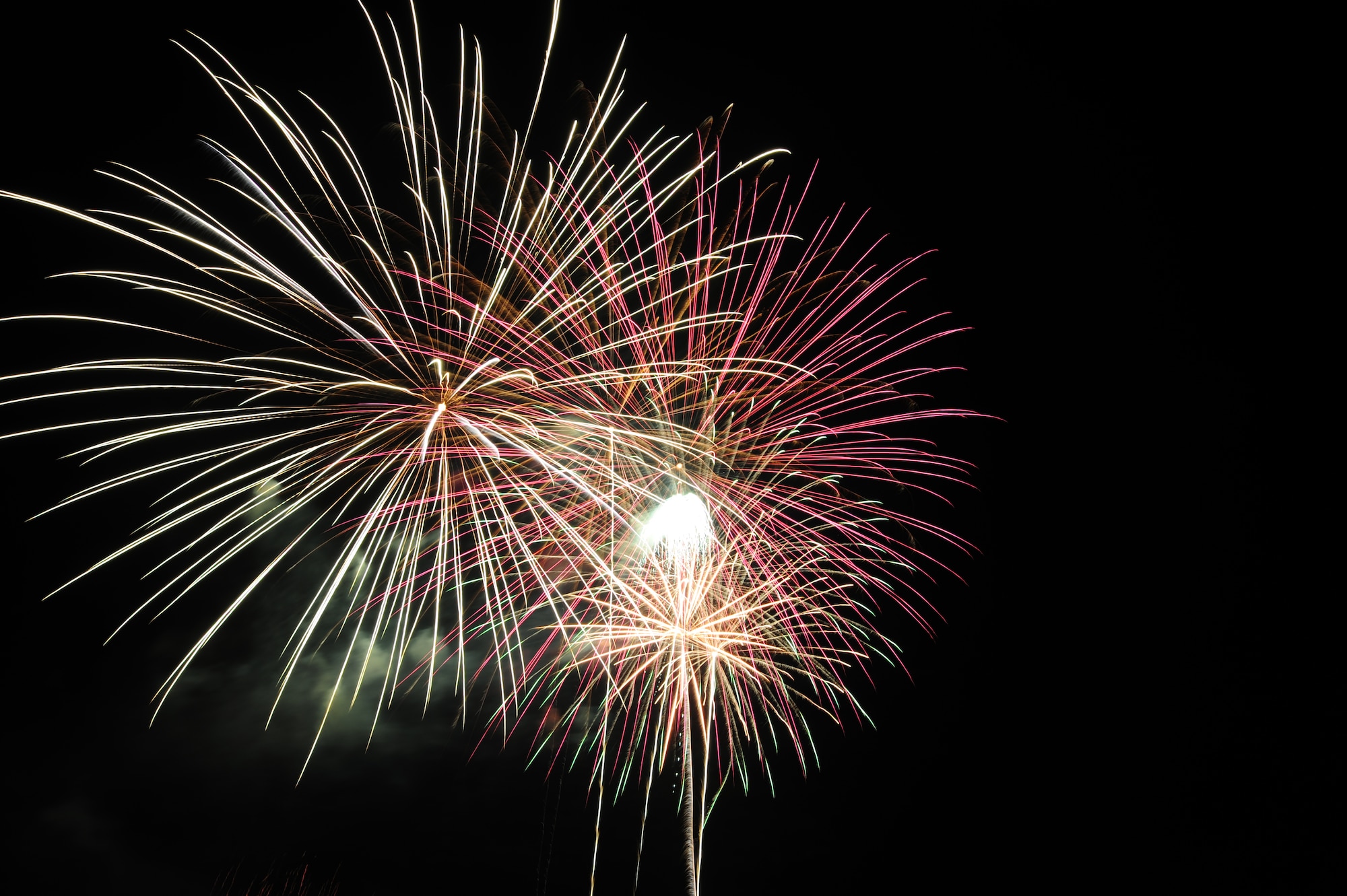 Fireworks are illuminated in the sky during a 4th of July celebration at Whiteman Air Force Base, Mo., July 3, 2013. Base members and their families took part in the annual celebration that also included face painting, a car show, a petting zoo and bouncy castles for children to play on. (U.S. Air Force photo by Staff Sgt. Nick Wilson/Released) 