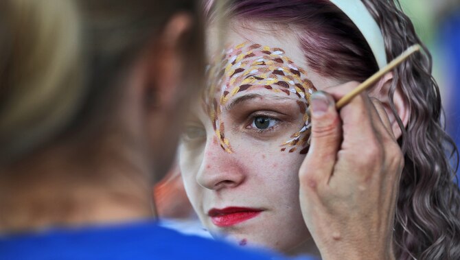 Katelyn Paul, wife of Senior Airman Kevin Paul, 509th Aircraft Maintenance Squadron, gets her face painted during a 4th of July celebration at Whiteman Air Force Base, Mo., July 3, 2013. In addition to face painting, the event also included a car show, a fireworks display, a petting zoo and bouncy castles for children to play on. (U.S. Air Force photo by Staff Sgt. Nick Wilson/Released)