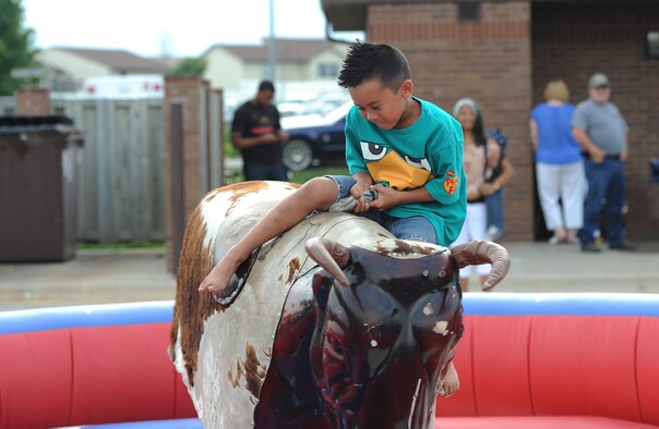Jaden Vergara, son of Staff Sgt. Jaime Vergara, 509th Medical Support Squadron, rides a mechanical bull during a 4th of July celebration at Whiteman Air Force Base, Mo., July 3, 2013. The 509th Force Support Squadron sponsored the event to celebrate Independence Day and show appreciation to the Whiteman community. (U.S. Air Force photo by Staff Sgt. Nick Wilson/Released)