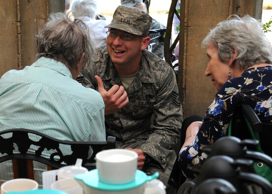 Tech. Sgt. Daniel Glynn, 100th Maintenance Group foreign object damage and dropped object prevention monitor from Victorville, Calif., shares a joke with residents at Stowlangtoft Hall nursing home July 11, 2013, in Suffolk, England. Twelve service members and Department of Defense personnel from Team Mildenhall volunteered to speak to residents, some of whom are Royal Air Force veterans, about their time in the U.S. Air Force. (U.S. Air Force photo by Gina Randall/Released)