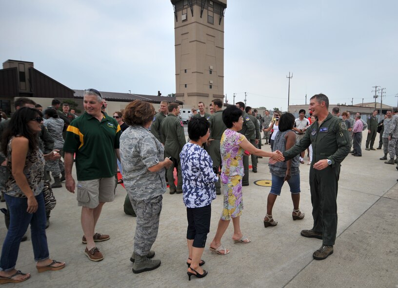 Col. Patrick McKenzie, 51st Fighter Wing commander, right, is congratulated by friends and family after completing his final flight at Osan Air Base, Republic of Korea, July 11, 2013. McKenzie, who has commanded the 51st FW since 2011, was entrusted with the operational readiness, training, morale, welfare, installation support, and quality of life of more than 5,500 personnel. (U.S. Air Force photo/Staff Sgt. Emerson Nuñez)