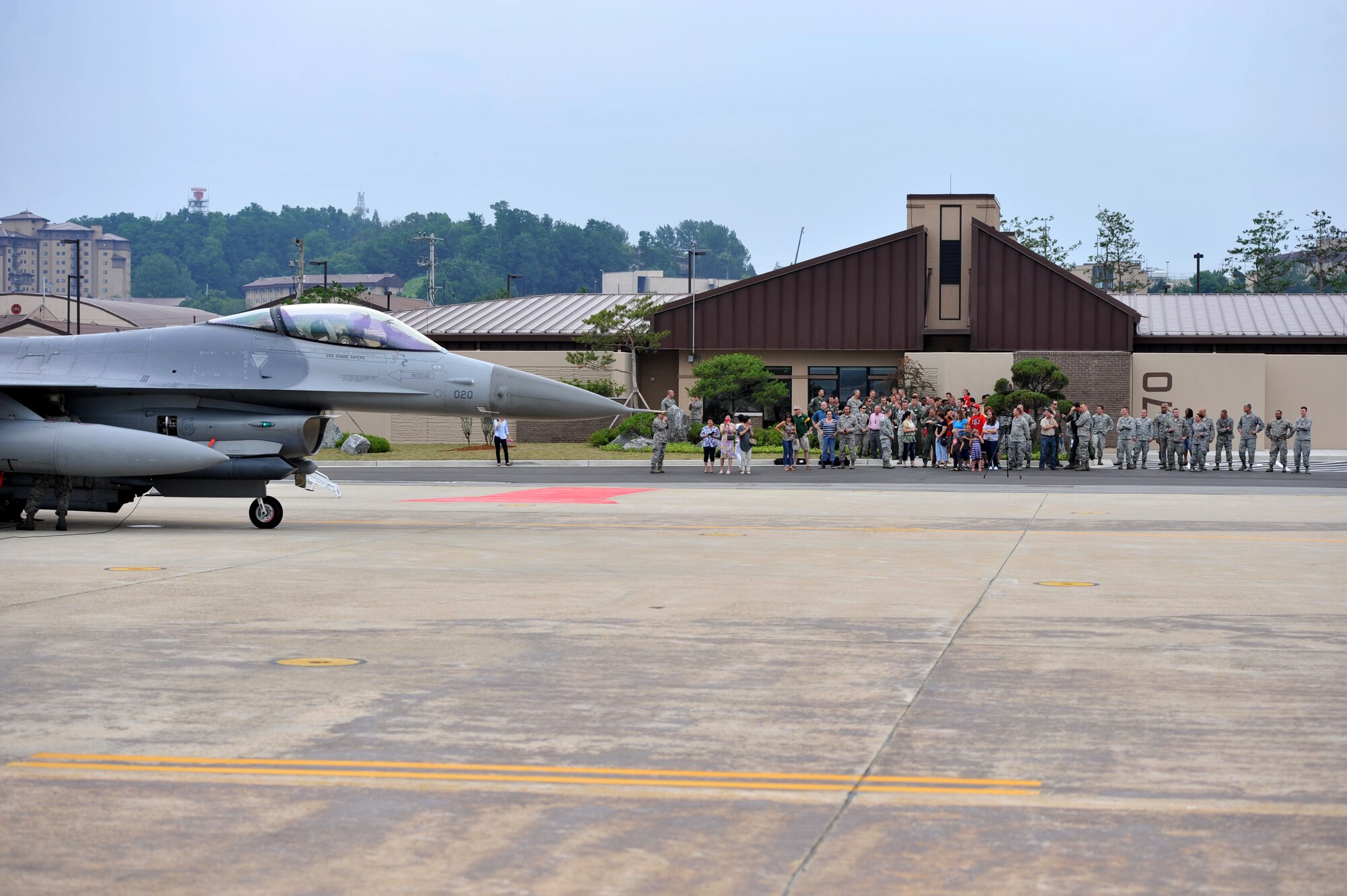 An F-16 Fighting Falcon piloted by Col. Patrick McKenzie, 51st Fighter Wing commander, taxies in as friends and family prepare to greet him following his final flight at Osan Air Base, Republic of Korea, July 11, 2013. As the 51st FW’s commander, McKenzie was responsible for ensuring the wing was always ready to defend Osan, execute combat operations, and receive follow-on forces. (U.S. Air Force photo/Staff Sgt. Emerson Nuñez)