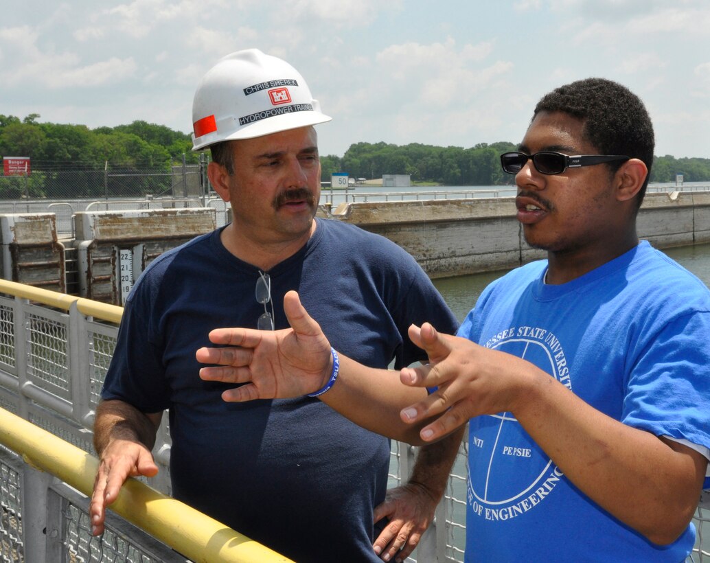 Chris Sherek, an Old Hickory Hydropower trainee at the Old Hickory Lock and Dam from the U.S. Army Corps of Engineers Nashville District talks with John Fitzgerald, Jr., a student from Memphis, Tenn about operation procedures at the Old Hickory Lock and Dam on June 27, 2013. Fitzgerald was part of a group of 17 students who attended the Tennessee State University Engineering Department's four-week National Summer Transportation Institute program that introduces students to various aspects of engineering.  


