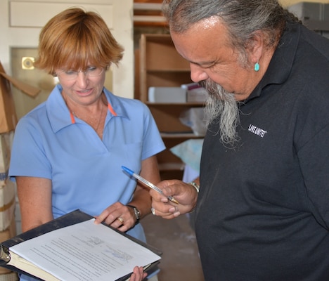 GALLUP, N.M., -- Ronald Maldonado, supervisory archaeologist for the Navajo Nation Historic Preservation Department and Julie Price, cultural resources project manager, U.S. Army Corps of Engineers, Omaha District, complete the paperwork transferring 425 sacred relics to the Navajo Nation July 9, 2013.