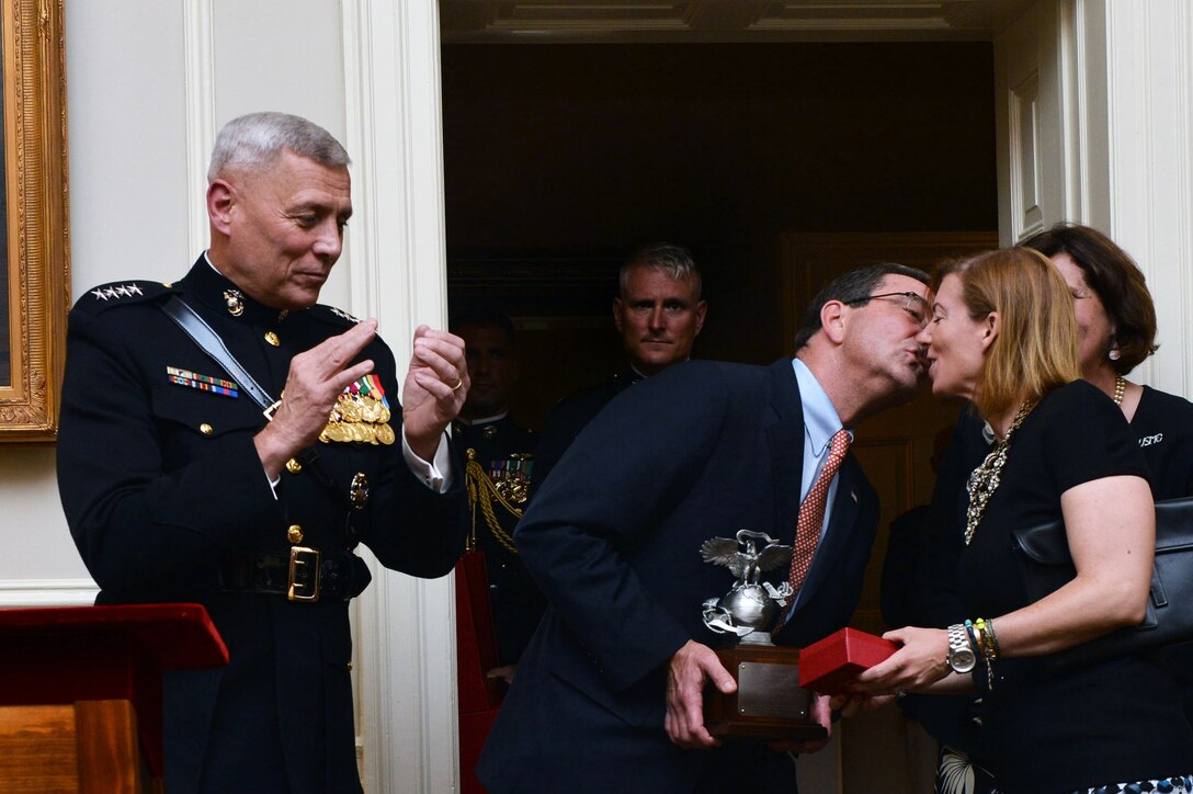 Deputy Defense Secretary Ash Carter gives his wife, Stephanie, a kiss, while serving as guest of honor for the parade at Marine Barracks Washington, July 12, 2013. Marine Corps Gen. John M. Paxton Jr., assistant commandant, applauded.