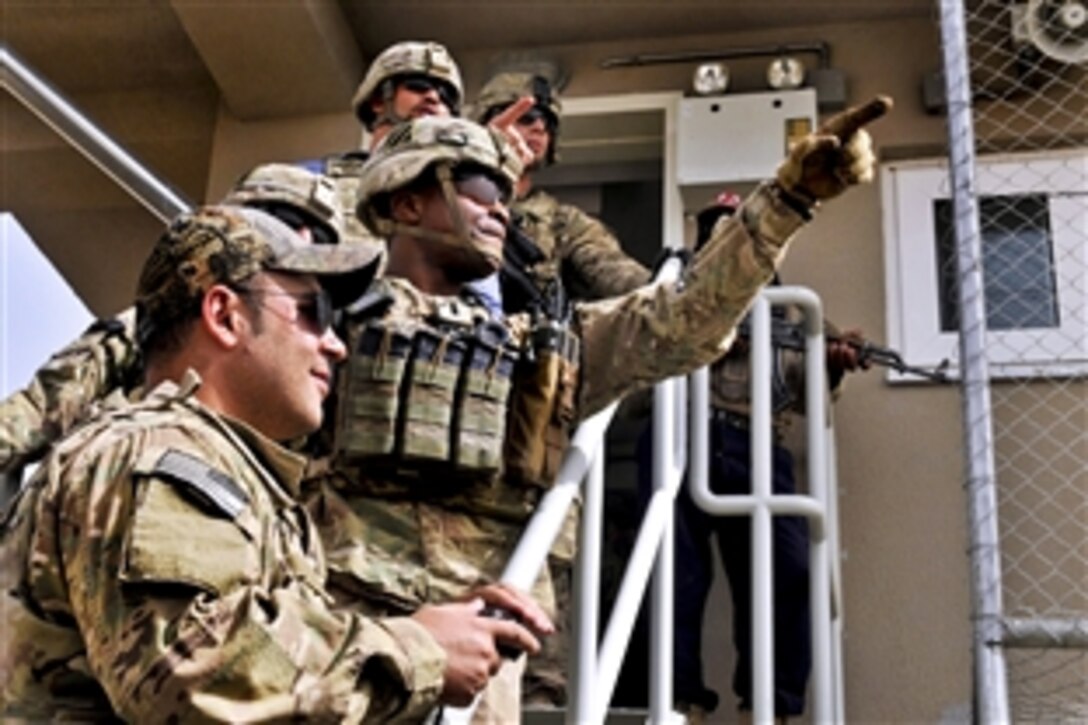U.S. soldiers point out an area of interest from a guard tower near the Afghanistan-Pakistan border crossing before escorting U.S. Army Maj. Gen. Paul J. LaCamera, the new commander of Regional Command South, in the Spin Boldak district in Afghanistan's Kandahar province, July 11, 2013.