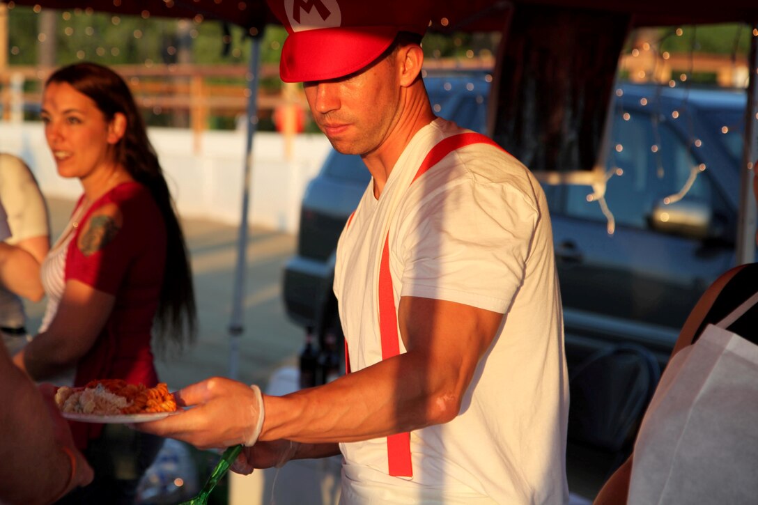 Pfc. Chris Laplant serves Italian food at the International Evening Under the Stars July 12 at the Lake O'Neil Peninsula, here. The event allowed the participants to try food and drinks from different countries around the world. Laplant was a volunteer for the Italy tent at the event.