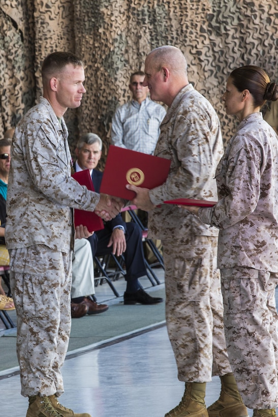Following the Deactivation Ceremony of Marine Attack Squadron 513, Lt. Col. Samuel Smith, the VMA-513 commanding officer, left, receives his certificate of retirement from Maj. Gen. Steven Busby, the commanding general of 3rd Marine Air Wing, center, and Sgt. Maj. Raquel Painter, the sergeant major of VMA-513, right, July 12, at the squadron hanger on Marine Corps Air Station Yuma, Ariz. Smith is the final commanding officer of “The Flying Nightmares.”