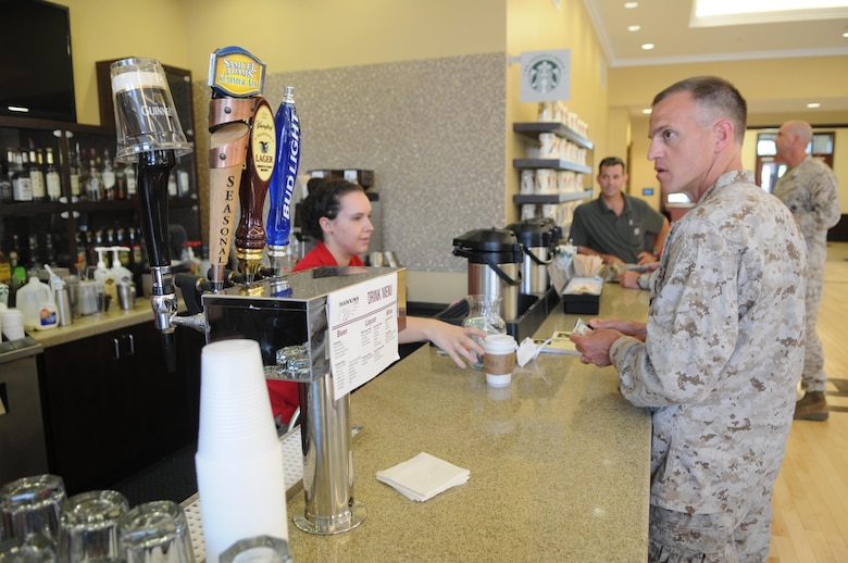 Lopez Hall, which opened in late June, includes a bar that doubles as a Starbucks. Here, Lt. Col. Keith Parrella gets a coffee from Starbucks worker Jenna Henning. The building’s new chow hall opened June 15, 2013, but the bar/Starbucks has been operating since June 27. 