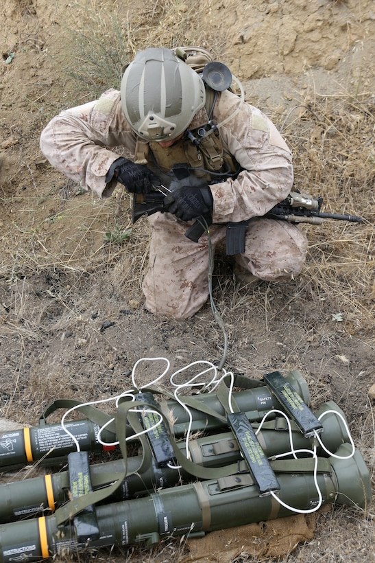Sergeant Nate Kerr, a reconnaissance Marine serving with Alpha Company, 1st Reconnaissance Battalion, sets his C-4 charges to destroy an enemy's weapons cache during a raid exercise here, July 10, 2013. Kerr, 25, from Dana Point, Calif.,  serves as the demolition expert for his team.