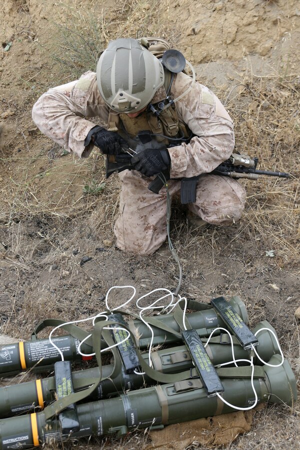 Sergeant Nate Kerr, a reconnaissance Marine serving with Alpha Company, 1st Reconnaissance Battalion, sets his C-4 charges to destroy an enemy's weapons cache during a raid exercise here, July 10, 2013. Kerr, 25, from Dana Point, Calif.,  serves as the demolition expert for his team.