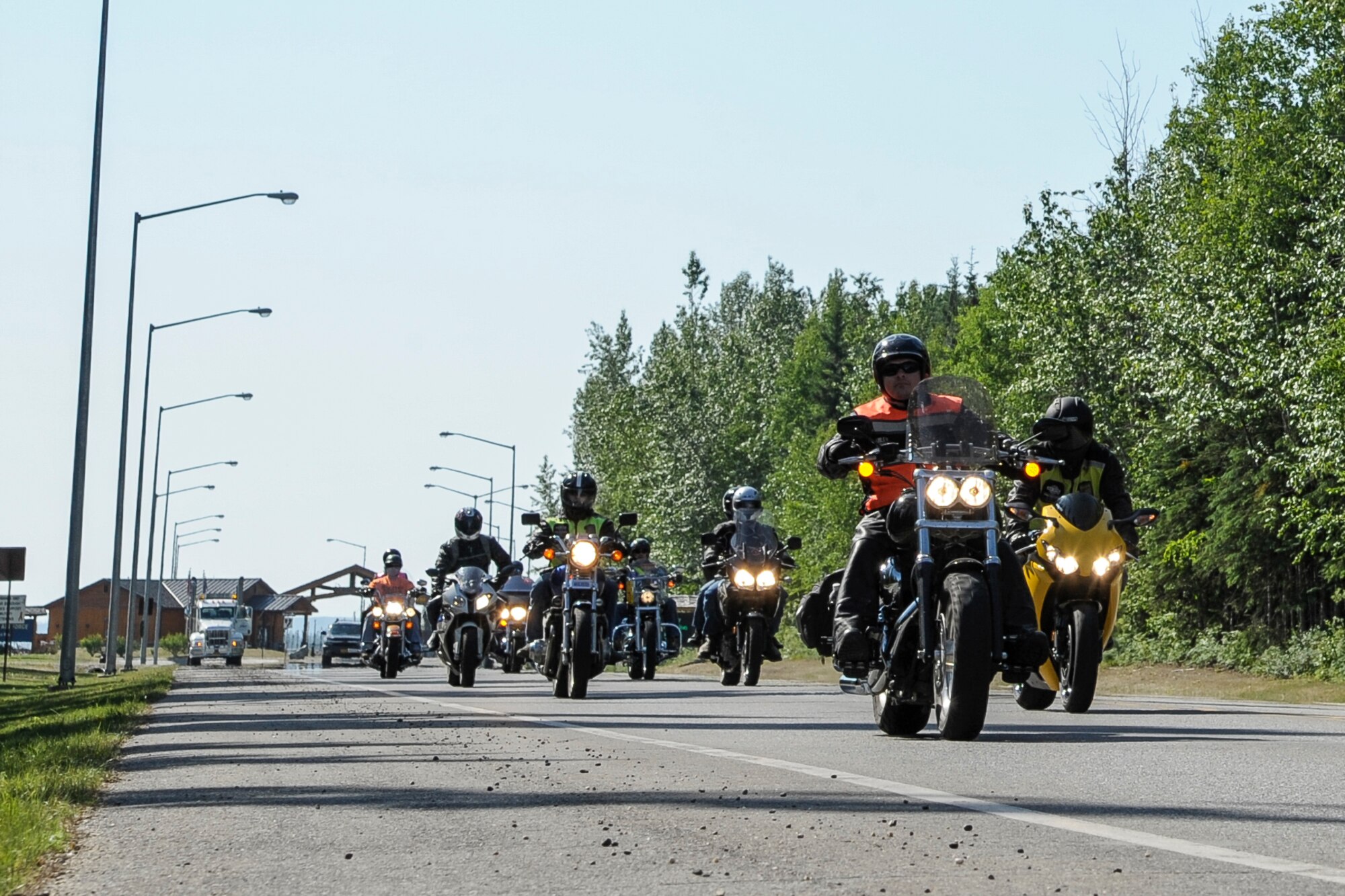 U.S. Air Force service members roll away from Hursey Gate during a motorcycle mentorship group ride June 22, 2013, Eielson Air Force Base, Alaska.  Mentorship rides are an opportunity for members of the Eielson community to not only practice motorcycle safety, but also to build camaraderie and meet other riders.  (U.S. Air Force photo by Airman 1st Class Peter Reft/Released)