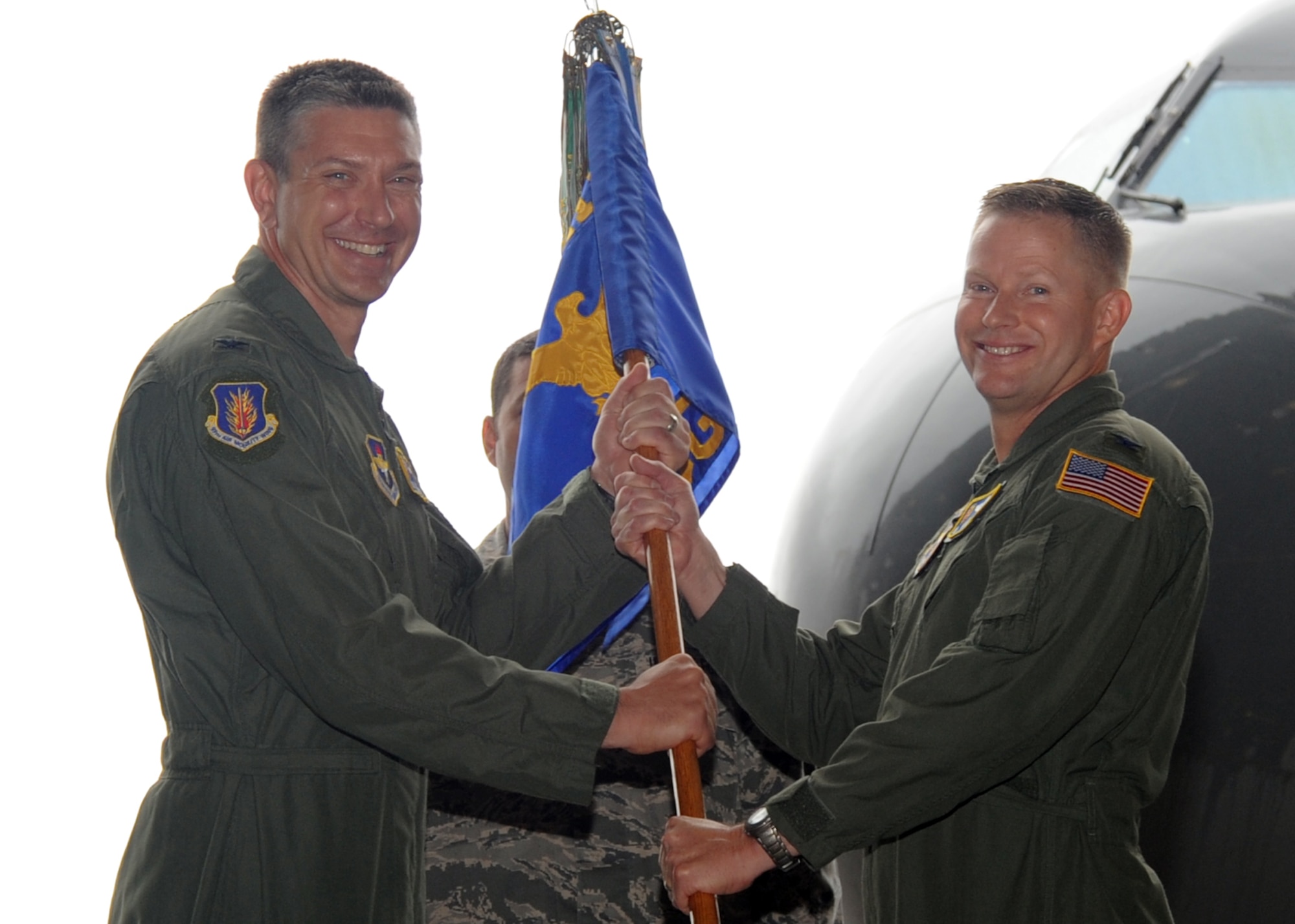 ALTUS AIR FORCE BASE, Okla. – Col. Bill Spangenthal, 97th Air Mobility Wing commander, passes the 97th Operations Group guidon to Col. Michael Finch, 97th OG commander, during a change of command ceremony, July 16. The event was held to relinquish command from Col. Ted Detwiler to Finch. (U.S. Air Force photo by Airman 1st Class Levin Boland / Released)