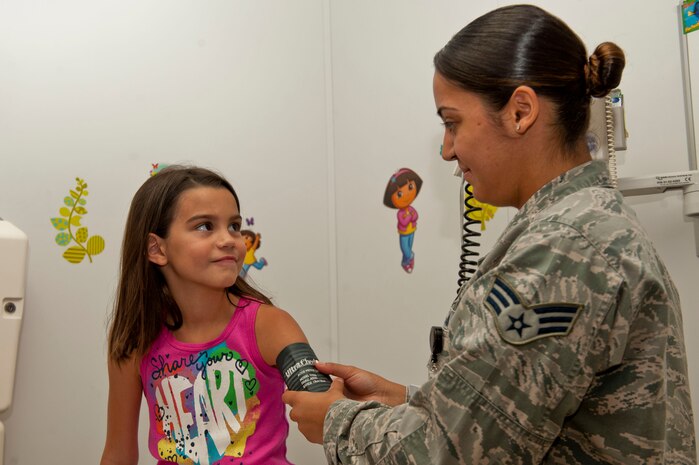 U.S. Air Force Senior Airman Ivana Jimenez, 99th Medical Operations Squadron medical technician, uses a blood pressure sleeve to take the blood pressure reading of Mia Hargrove, daughter of Christina Hargrove, during a sports physical July 16, 2013, at the pediatric clinic at Nellis Air Force Base, Nev. The pediatric clinic will hold its annual school and sports physicals for children aged 6-17 at the family medicine clinic through the month of August, to make an appointment for their child’s sports physical by calling 653-CARE (2273). (U.S. Air Force photo by Senior Airman Daniel Hughes)