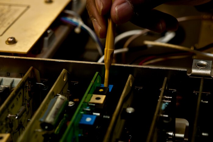 U.S. Air Force Airman 1st Class Bruce Jackson, 99th Communications Squadron airfield systems technician, inspects a communication radio July 15, 2013, at Nellis Air Force Base, Nev. Radio communication between pilots and the control tower are very important and the airfield systems Airmen ensure that the communications are reliable. (U.S. Air Force photo by Senior Airman Daniel Hughes)