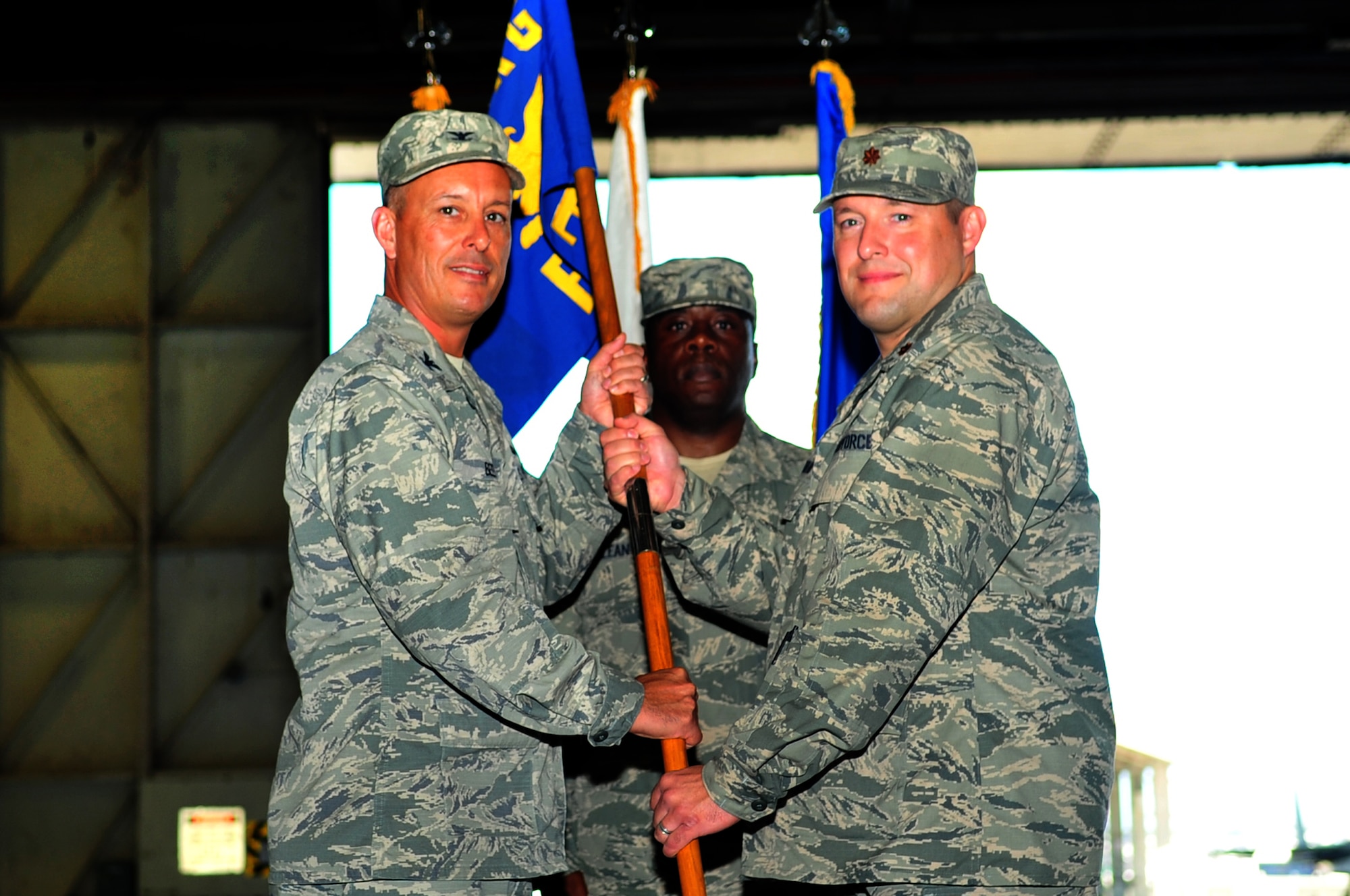 U.S. Air Force Col. Brian Beers, 18th Maintenance Group commander, presents the guidon to Maj. Jason Rabideau, 18th Equipment Maintenance Squadron commander, during an assumption of command ceremony on Kadena Air Base, Japan, July 16, 2013. Rabideau comes from Maxwell Air Force Base, Ala., where he attended Air Command and Staff College. Prior to attending school, Rabideau served as the commander of the 432nd Maintenance Squadron at Creech Air Force Base, Nev.  (U.S. Air Force photo by Senior Airman Amber E. N. Jacobs/Released)