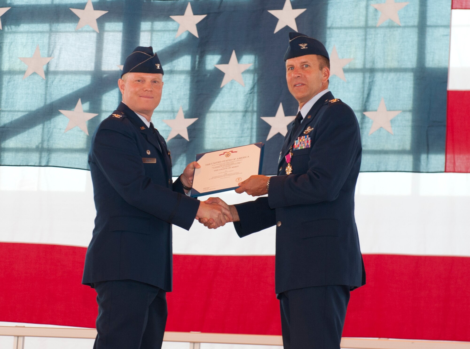 Colonel Kenneth Johnson, 49th Operations Group outgoing commander, receives a Meritorious Service Medal from Col. Andrew Croft, 49th Wing commander, during the 49th Operations Group change of command ceremony at Holloman Air Force Base, N.M., June 12. In the ceremony Col. Mark Hoehn assumed command of the 49th OG from Col. Kenneth Johnson. The group is home to the Air Force’s most combat-ready F-22 Raptor squadron and is a formal training unit for MQ-1 Predator and MQ-9 Reaper aircrew, graduating around 700 crews per year. (U.S. Air Force photo by Airman 1st Class Daniel E. Liddicoet/Released)