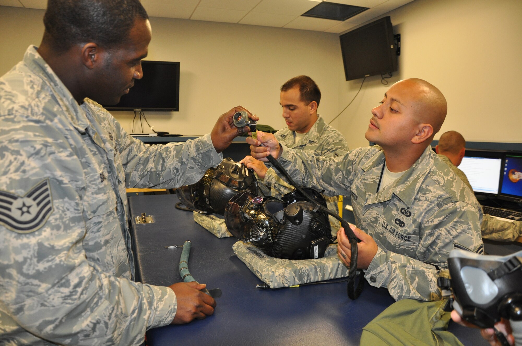 Tech. Sgt. Andre Baskin (left) and Tech. Sgt. Lemuel Velazquez (right), inspect the optical cable of the F-35 Lightning II helmet June 24, 2013 at the 33rd Fighter Wing, Eglin AFB, Fla. The members are part of the 33rd Operations Support Squadron Aircrew Flight Equipment Flight and ensure the pilots have well-maintained gear, which provides enhanced situational awareness, targeting information and symbology capabilities displayed on the visor of the helmet. (U.S. Air Force photo by Maj. Karen Roganov)