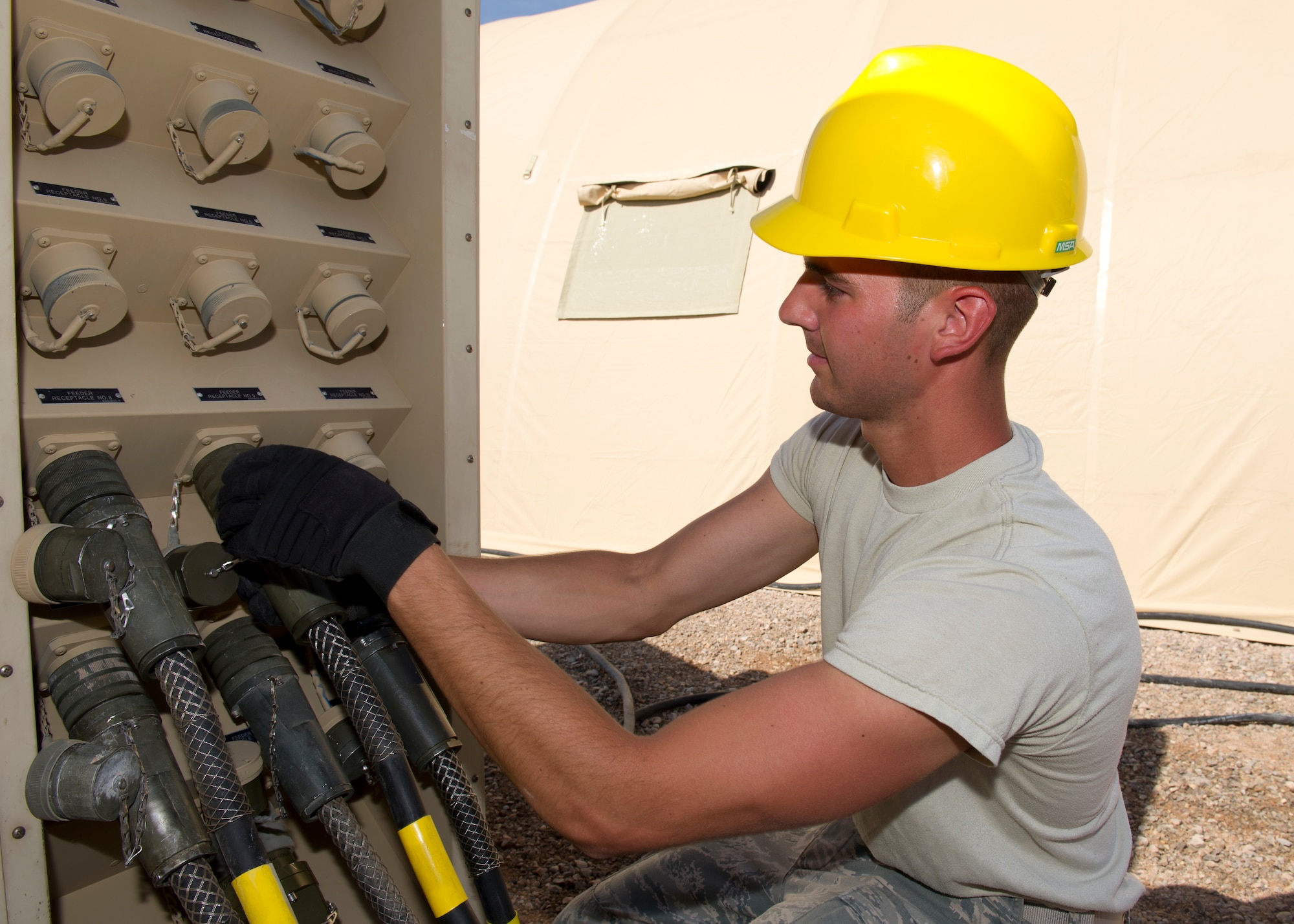 Airman 1st Class Brett Fredrickson, 49th Materiel Maintenance Squadron electrical systems apprentice, installs a 60-amp cable to a secondary distributor center to supply power to a latrine facility during a Basic Expeditionary Airfield Resources Base five-day training exercise at Holloman Air Force Base, N.M., July 10. The training mimicked conditions the Airmen would encounter at a deployed location. (U.S. Air Force photo by Senior Airman Kasey Close/Released)