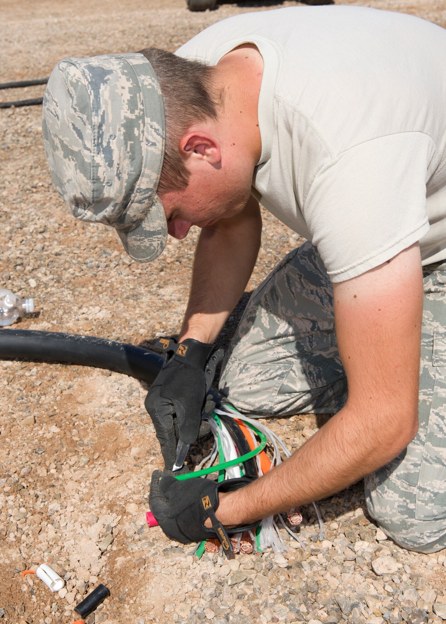 Airman 1st Class Keith Stoeber, 49th Materiel Maintenance Squadron power production apprentice, splices a wire in preparation to parallel two generators during a Basic Expeditionary Airfield Resources Base five-day training exercise at Holloman Air Force Base, N.M., July 10. Paralleling the generators will prevent system overload for the generators. (U.S. Air Force photo by Senior Airman Kasey Close/Released)
