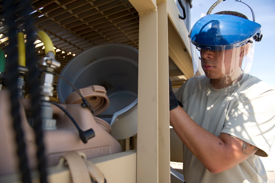 Senior Airman Trevor Dickerson, 49th Materiel Maintenance Squadron utilities shop journeyman, pours a chemical into a reverse osmosis water purification system during a Basic Expeditionary Airfield Resources Base five-day training exercise at Holloman Air Force Base, N.M., July 10. The system allows Dickerson to retrieve water from a natural source and produce drinking water. (U.S. Air Force photo by Senior Airman Kasey Close/Released)